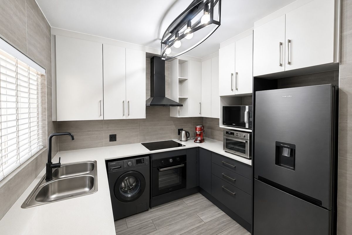 Modern, well-appointed kitchen featuring sleek two-tone cabinetry, quartz countertops, integrated appliances, and high-quality finishes throughout.