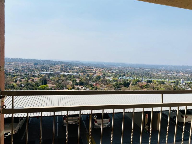 Elevated balcony view overlooking the surrounding suburban landscape and parking area.