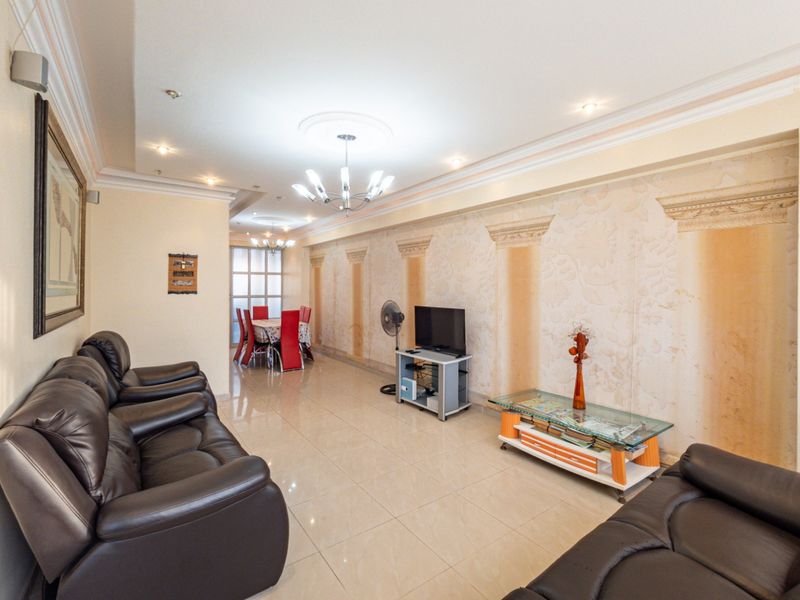 Spacious open-plan living and dining area featuring tiled flooring, decorative ceiling cornicing, and a unique textured feature wall with classical architectural motifs.