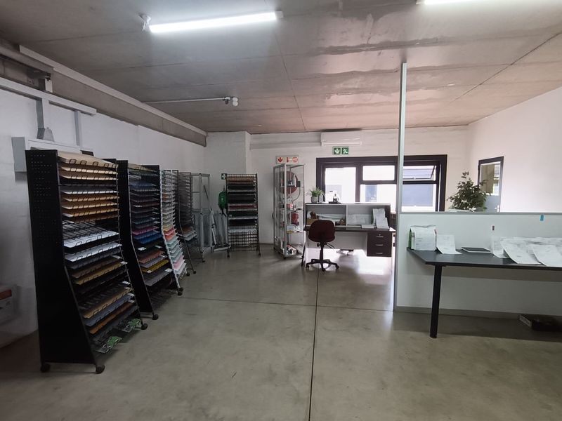 A functional commercial office space featuring concrete flooring, split-system air conditioning, and partition walls, suitable for a variety of business operations.