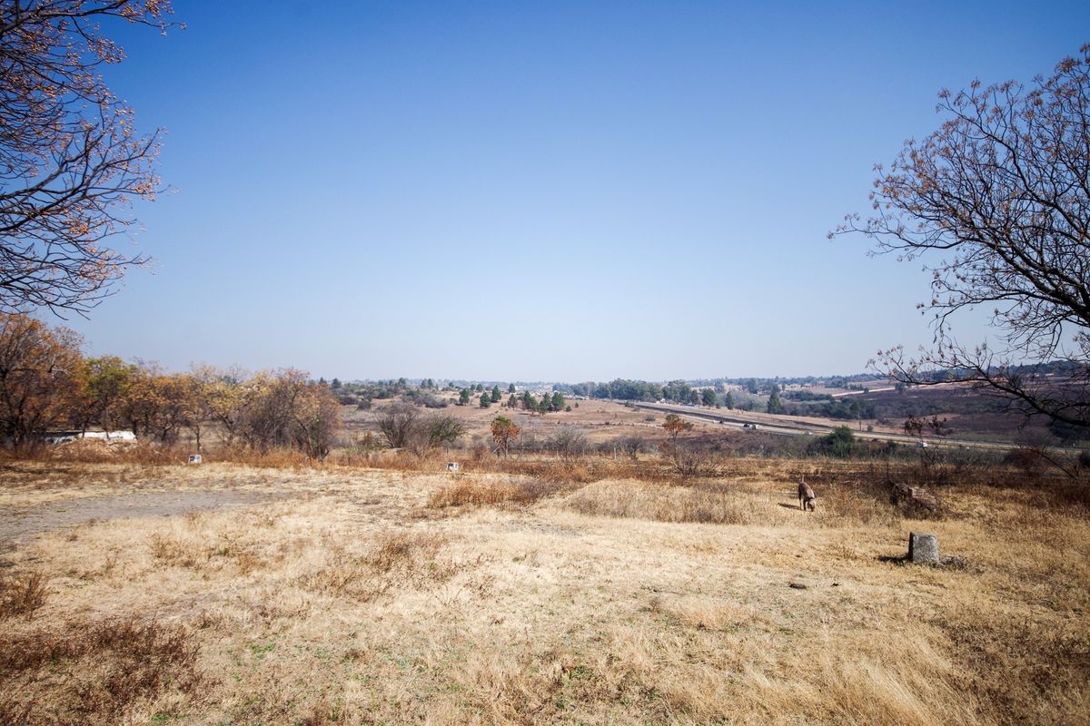 A wide-angle view of the expansive rural landscape and surrounding farm terrain under a clear blue sky.