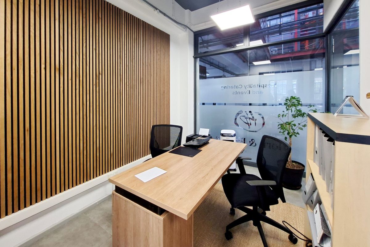 Modern office space featuring a contemporary timber slat feature wall, large glass partitions with privacy film, and clean, professional finishes.