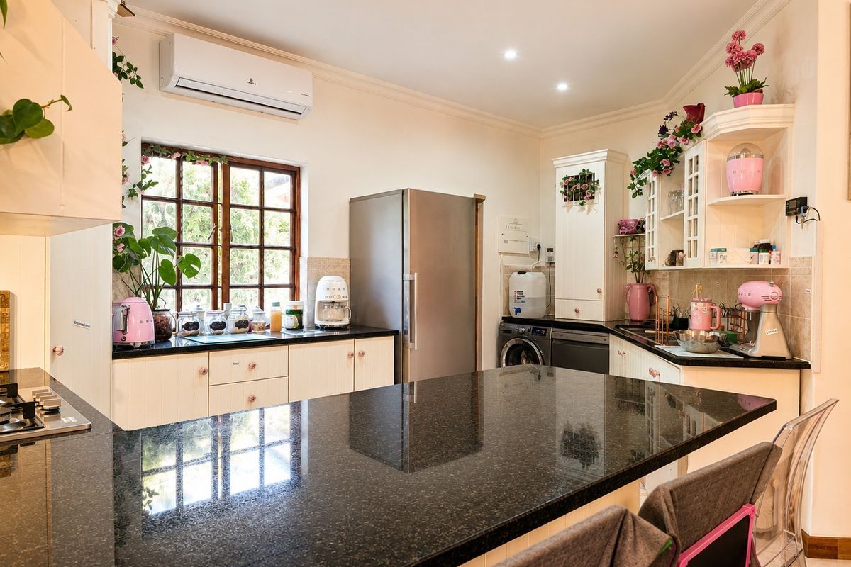 A well-appointed kitchen featuring granite countertops, ample built-in cabinetry, integrated appliances, and a split-system air conditioner for climate control.