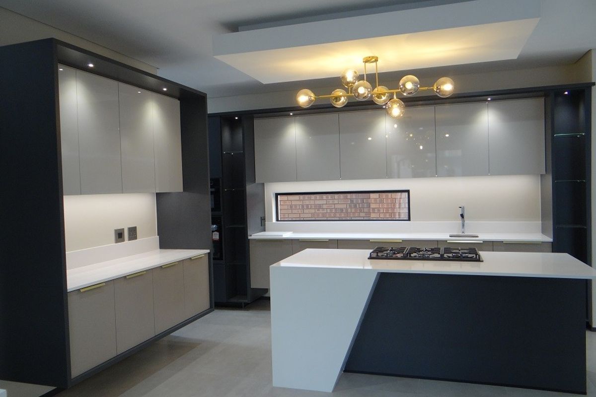 Modern, high-end kitchen featuring sleek built-in cabinetry, a large central island with a gas hob, stone countertops, and sophisticated recessed lighting.
