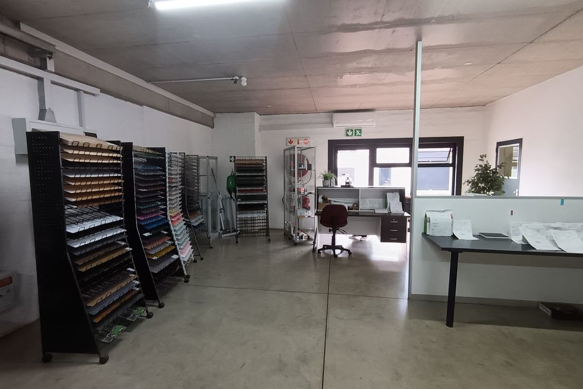 A functional commercial office space featuring concrete flooring, split-system air conditioning, and partition walls, suitable for a variety of business operations.