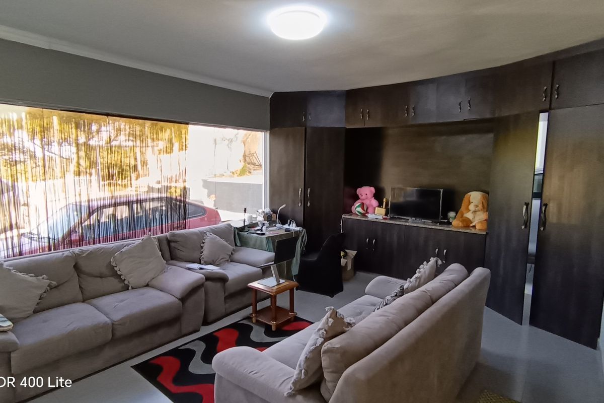 A living room featuring extensive dark wood built-in cabinetry and a large window providing natural light.