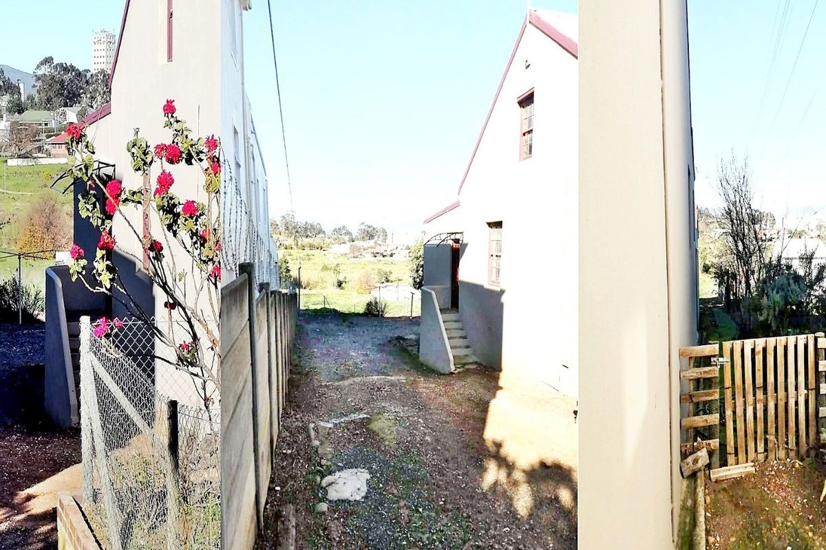 A rear exterior view of the property showing a side pathway, concrete boundary wall, and a timber gate leading to the backyard area.
