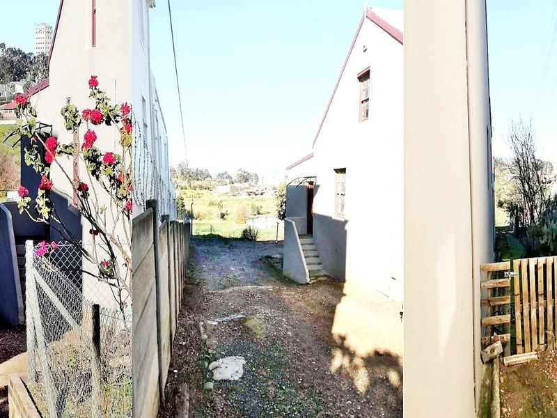 A rear exterior view of the property showing a side pathway, concrete boundary wall, and a timber gate leading to the backyard area.