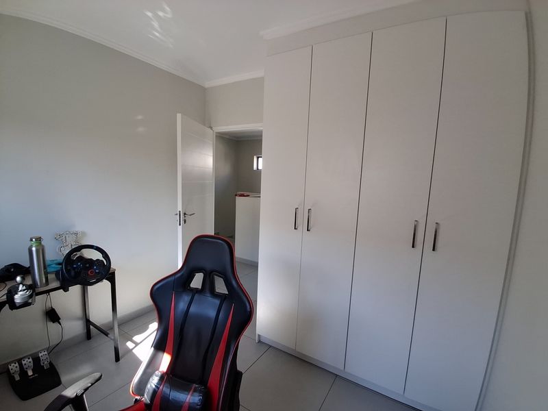 A bedroom featuring neutral walls, tiled flooring, and ample built-in cupboard storage space.