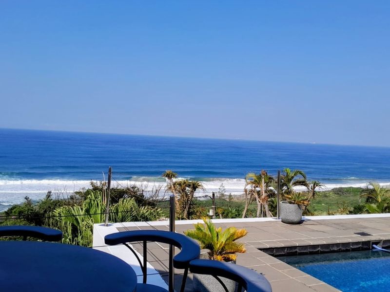 Outdoor pool area featuring a tiled deck, modern cable balustrade, and expansive, unobstructed ocean views.