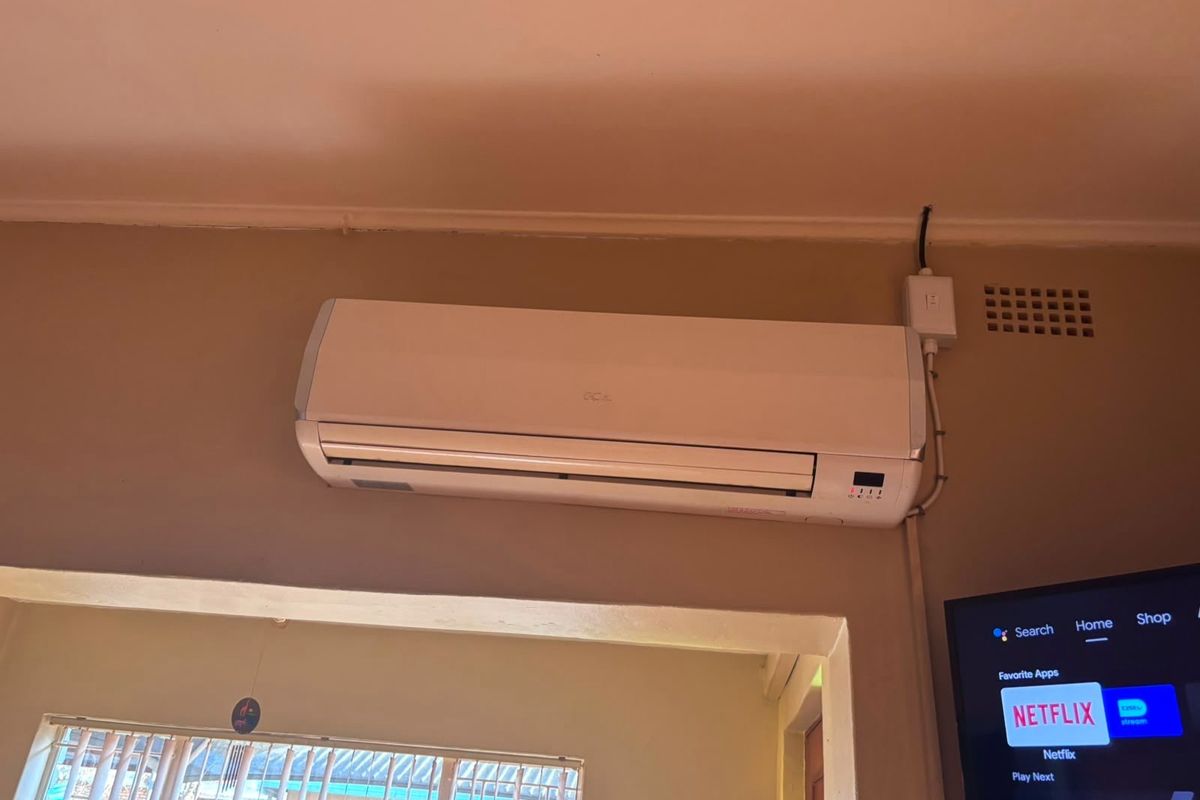 A living room interior featuring a wall-mounted air conditioning unit and visible ventilation infrastructure.