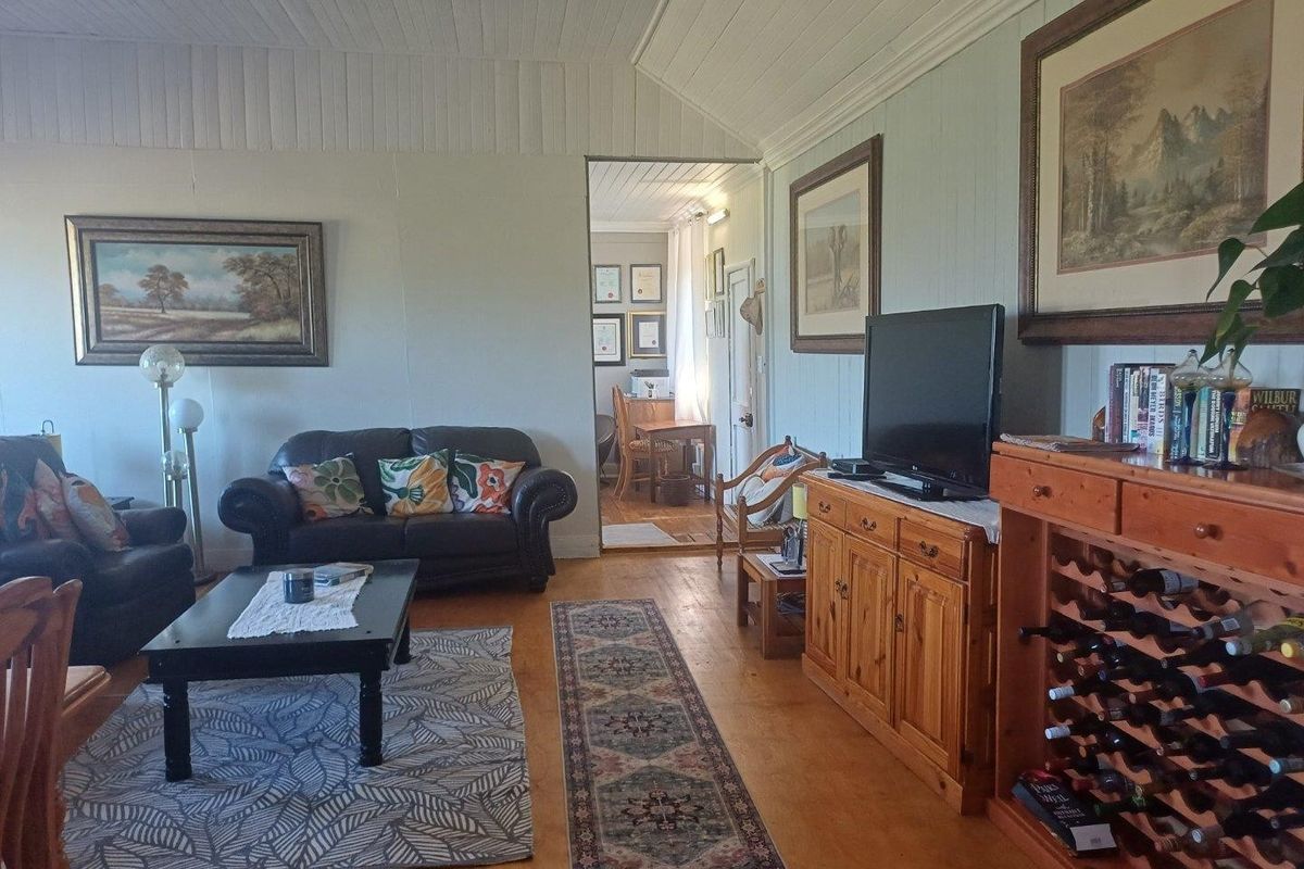 A cozy living room featuring traditional timber wall panelling, a vaulted timber ceiling, and warm timber flooring, creating a classic farmhouse atmosphere.