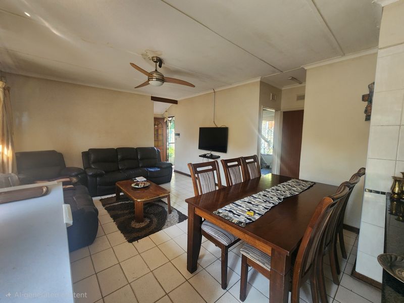Open-plan living and dining area featuring tiled flooring and a ceiling fan, showing signs of ceiling wear and water staining.