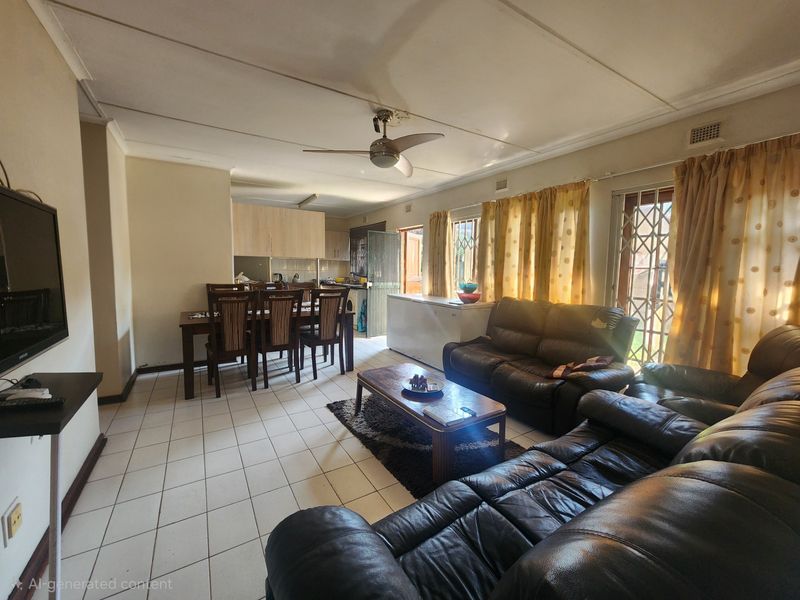 Open-plan living and dining area featuring tiled floors, a ceiling fan, and an integrated kitchen space with built-in cabinetry.