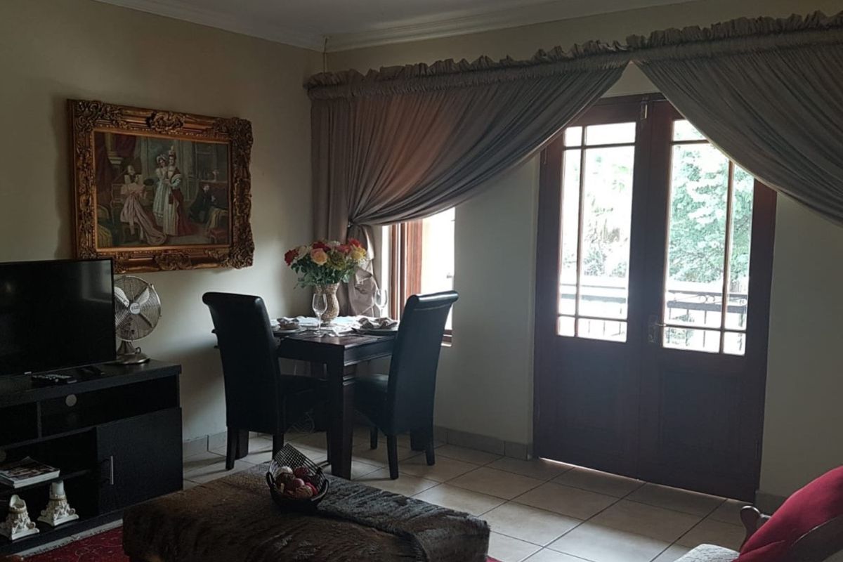 A living room featuring tiled flooring, coving, and double french doors providing access to the exterior.