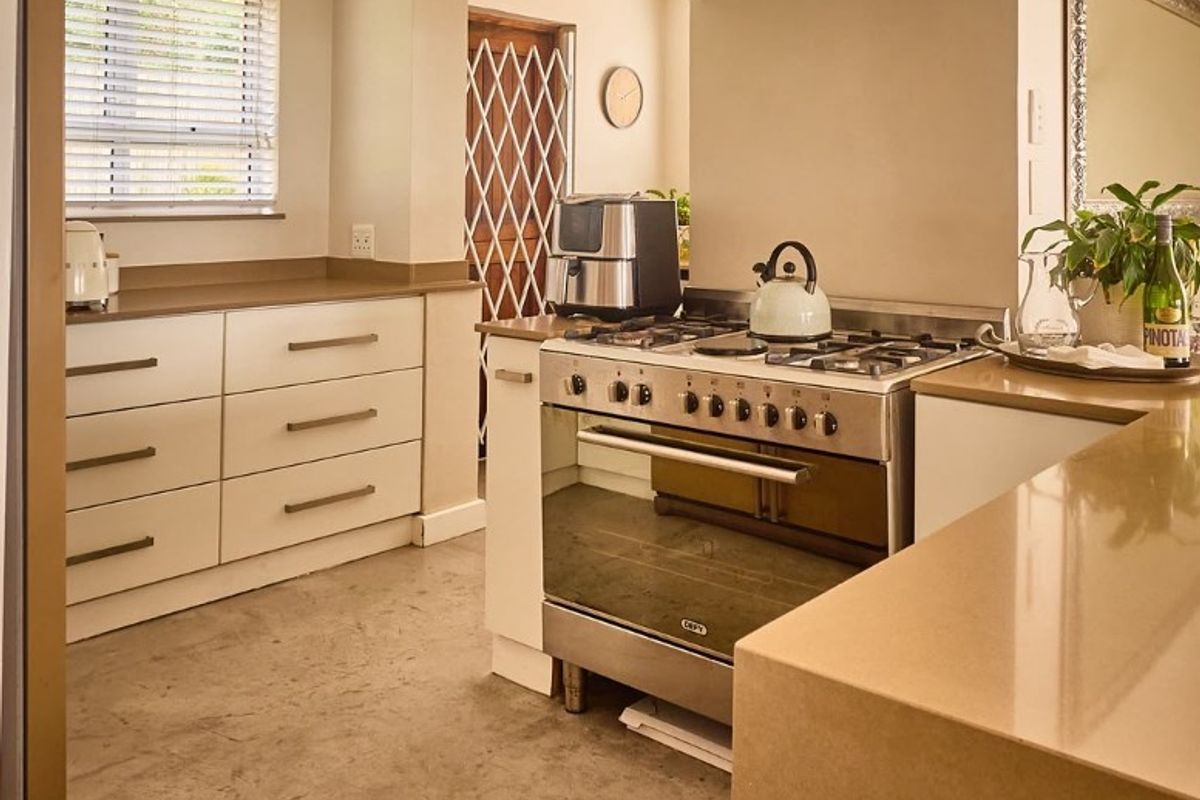 Modern kitchen featuring quartz countertops, built-in cabinetry, a stainless steel gas stove with extractor fan, and recessed lighting.