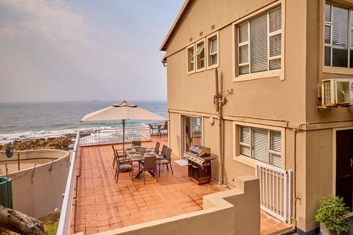 Spacious rear patio featuring terracotta tiling and direct ocean views, providing an ideal outdoor entertainment area attached to the apartment.