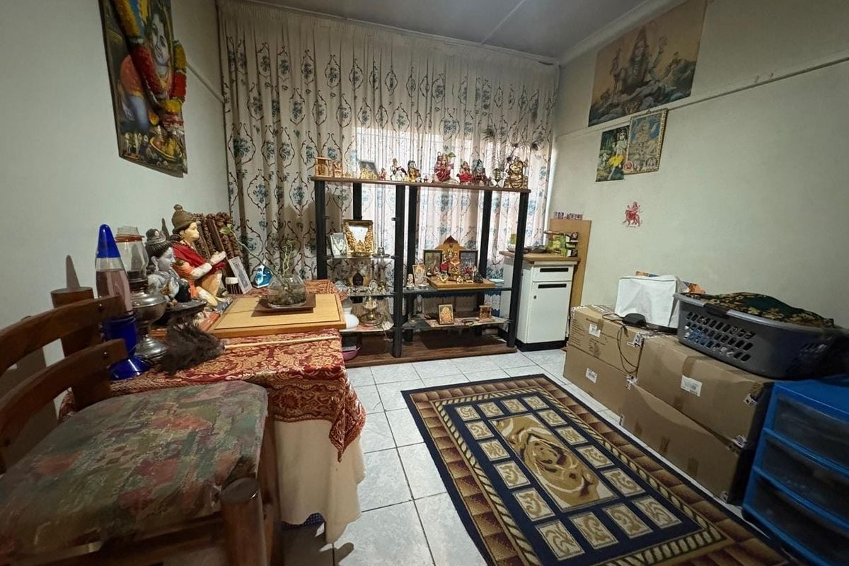 A living area featuring tiled flooring and window curtain tracks, currently utilized as a multi-purpose space.