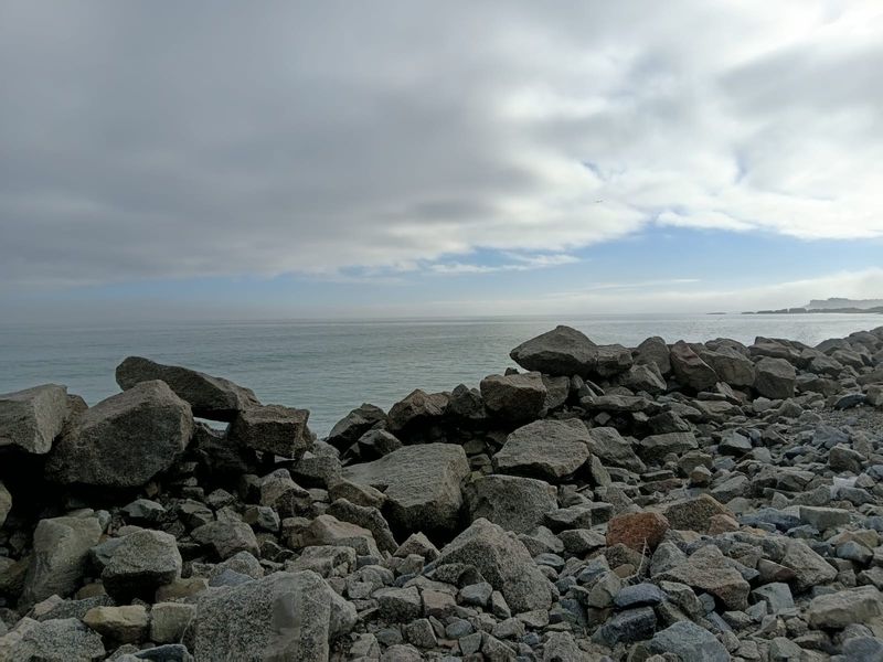 A scenic view of the rocky coastline and ocean, showcasing the natural landscape of the vacant residential property.