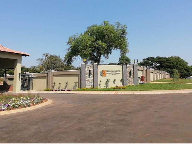 The entrance to Yellow Wood Estate featuring a secure perimeter wall, electric fencing, and well-maintained landscaped grounds.