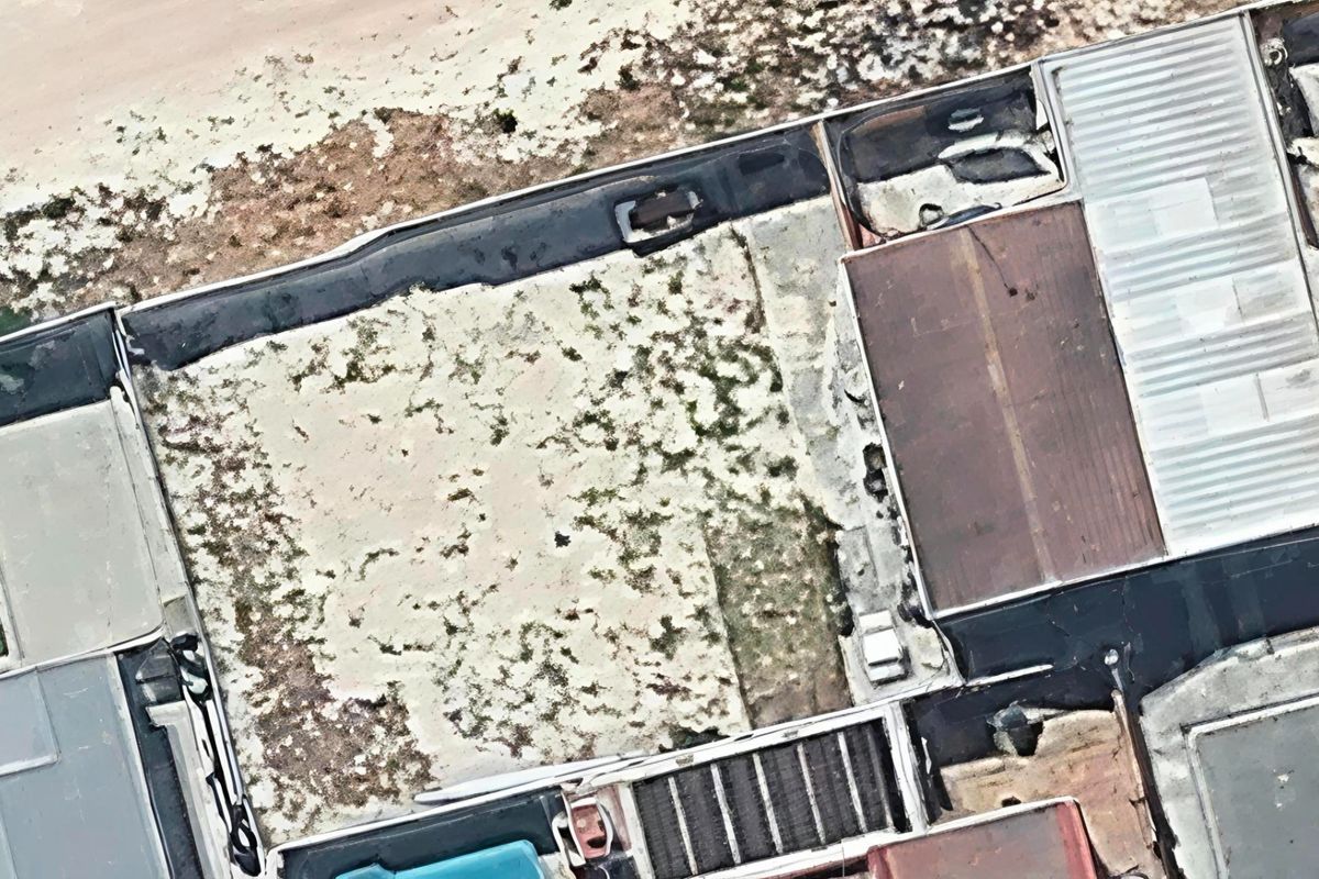 An aerial view of the property showing the roof structure and surrounding outdoor area with signs of significant wear and maintenance requirements.