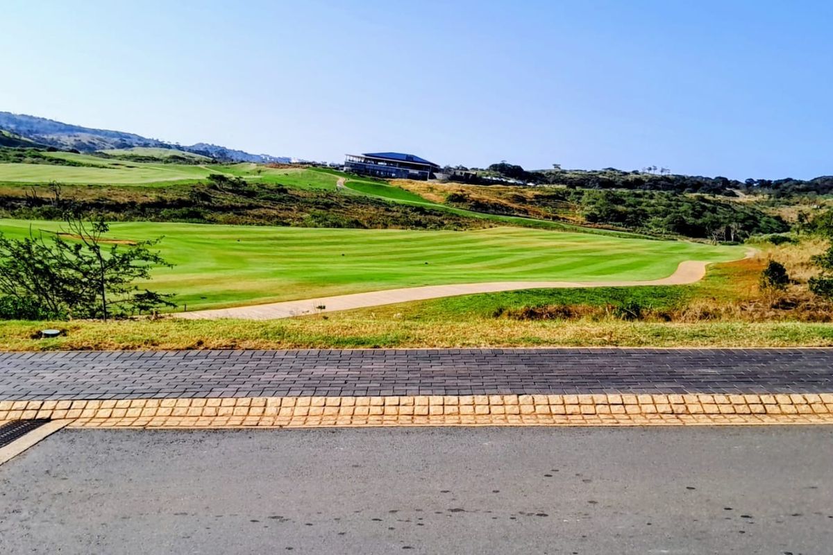 A scenic view overlooking a well-maintained golf course with a paved walkway in the foreground.