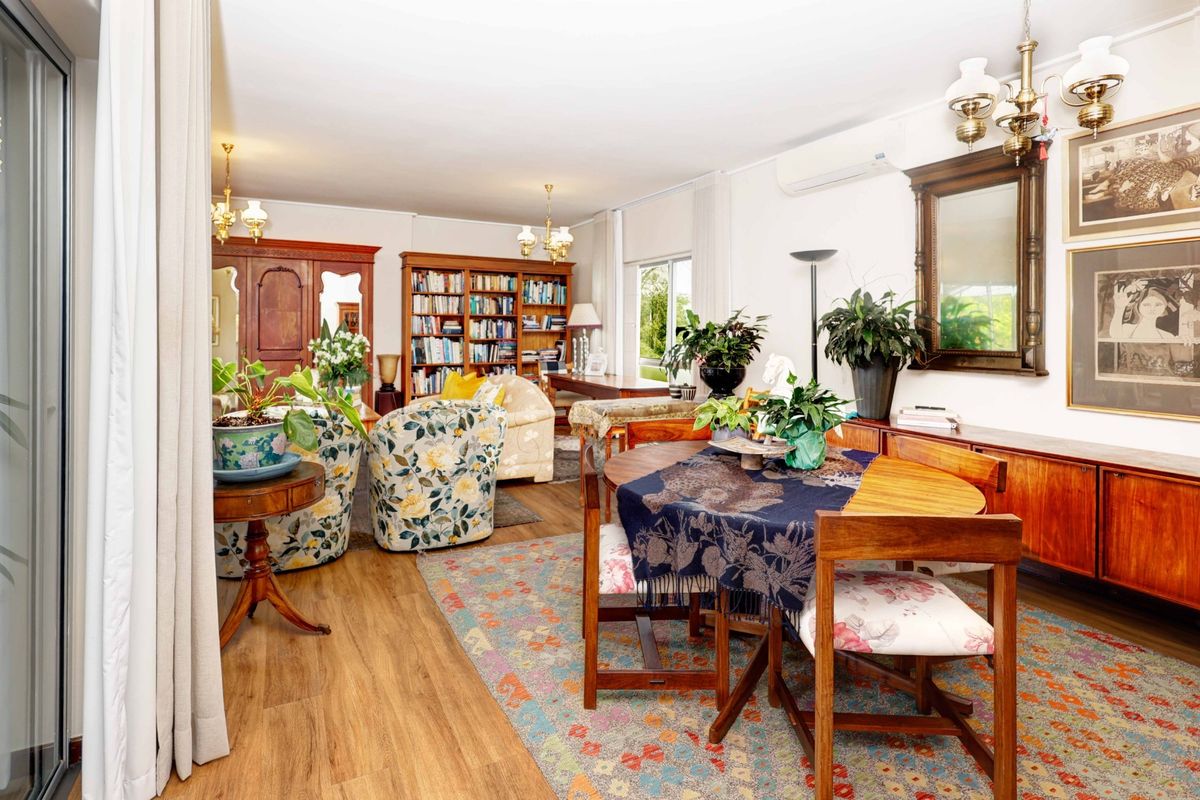 Spacious living and dining area featuring laminate flooring, built-in shelving, and a split-system air conditioner with access to an outdoor area.