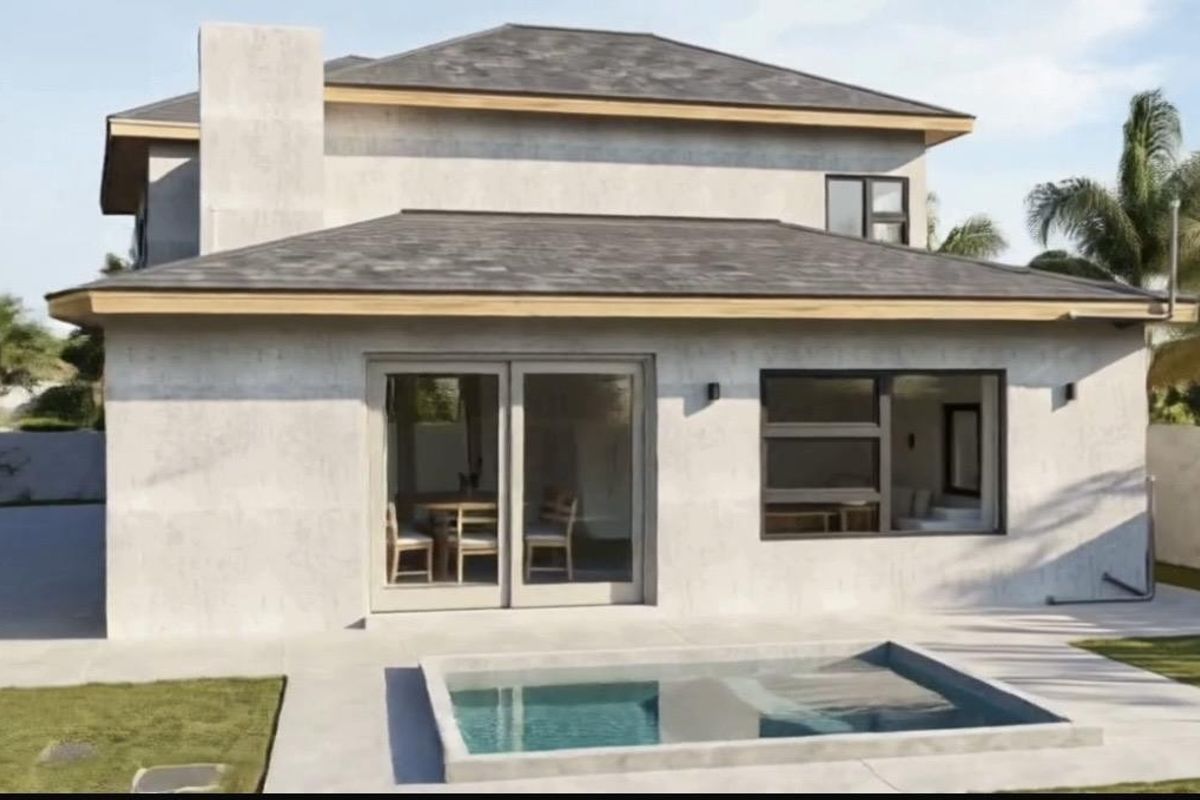 Rear view of a modern two-story house featuring a concrete patio, a small swimming pool, and large sliding glass doors.