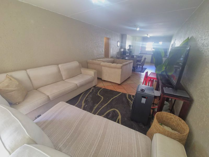 Open-plan living and dining area featuring tiled flooring and textured wall finishes, providing a functional layout for daily living.