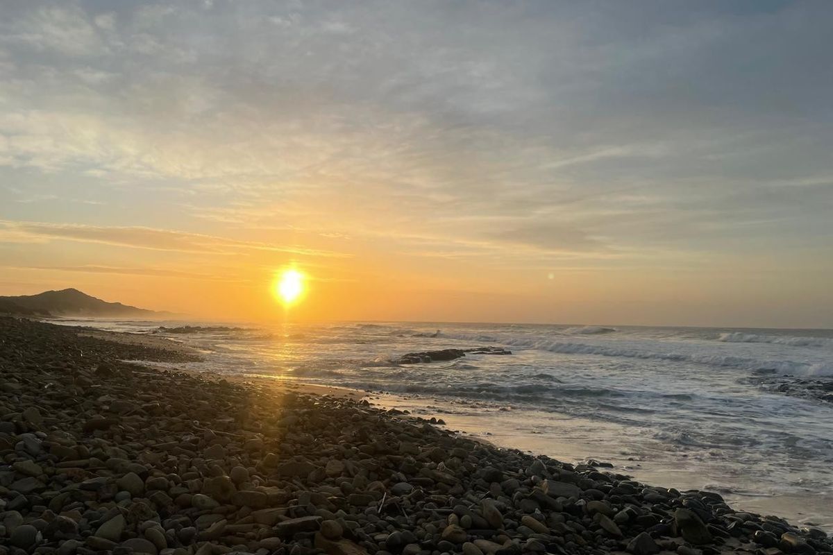 A scenic view of the coastline at sunset, showcasing the natural landscape and ocean horizon.