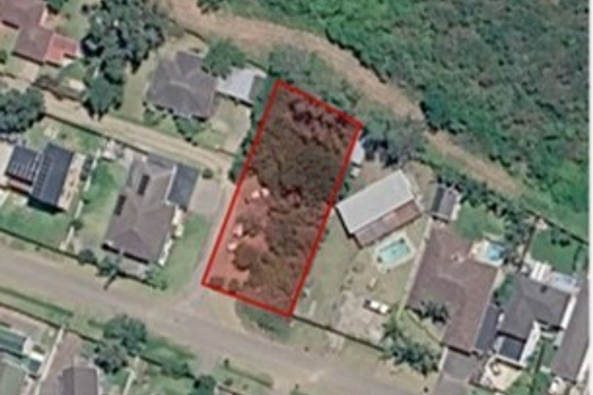 An aerial view of a vacant residential plot highlighted in red, situated within an established suburban neighborhood.