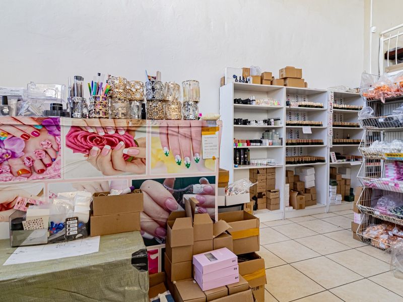 A commercial utility or storage area featuring tiled flooring and multiple built-in shelving units for organized inventory management.
