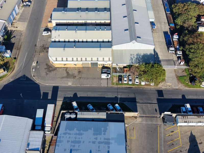 Aerial view of an industrial property complex featuring multiple warehouse buildings, paved parking areas, and secure gated access.