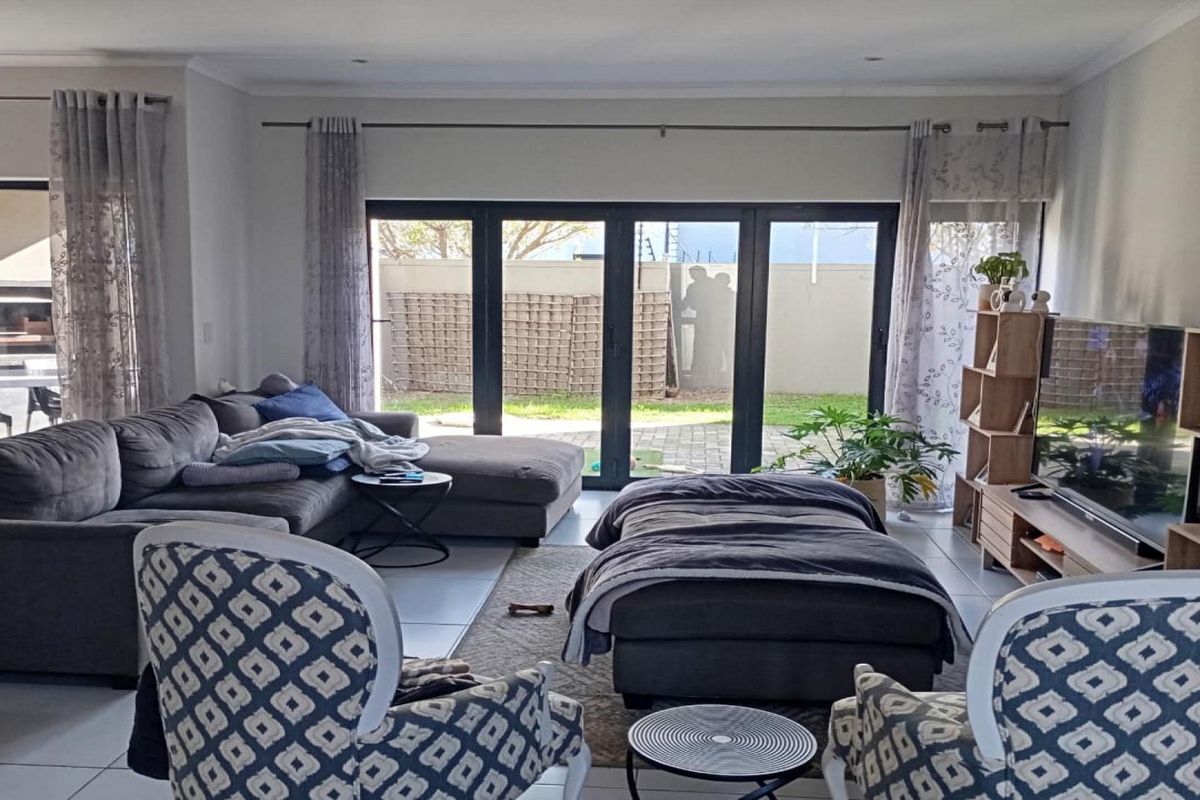 A spacious living room featuring large sliding glass doors that provide natural light and direct access to the outdoor patio area.