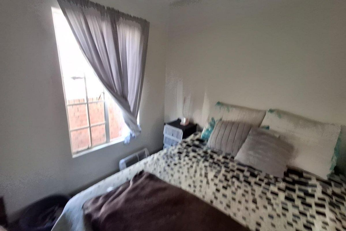 A standard bedroom featuring a window with natural light, providing a functional space for rest.