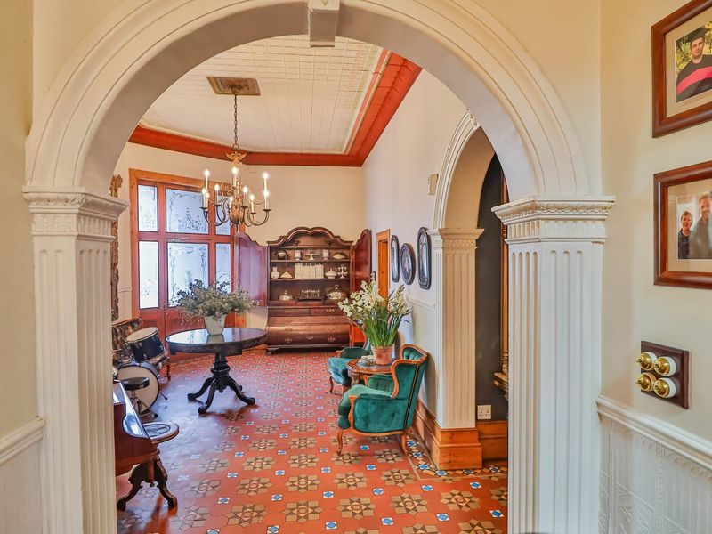 Elegant entrance hall featuring classic archways, intricate patterned tile flooring, and a decorative ceiling, creating a sophisticated and welcoming atmosphere.
