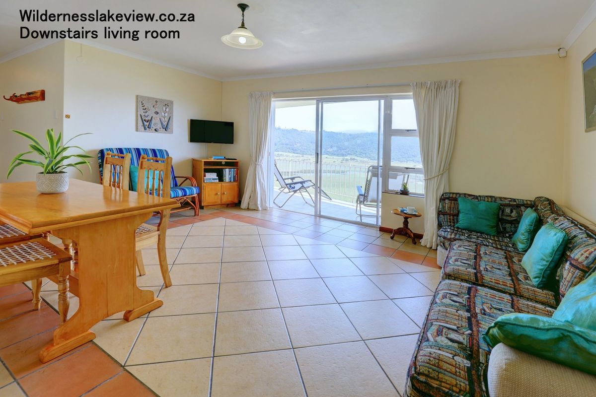 Spacious living area featuring tiled flooring and large sliding glass doors that provide access to an outdoor balcony with scenic views.