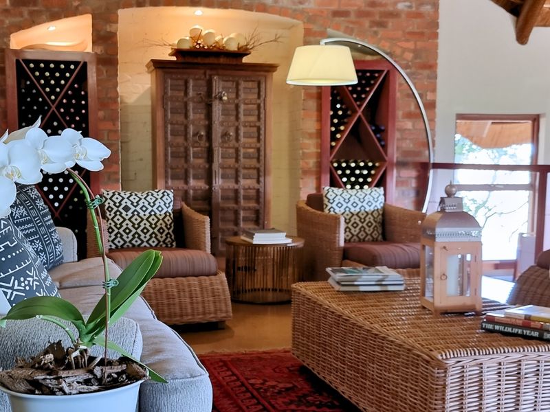 A cozy living area featuring exposed brick walls, built-in wine storage racks, and arched architectural alcoves, creating a warm and rustic atmosphere.