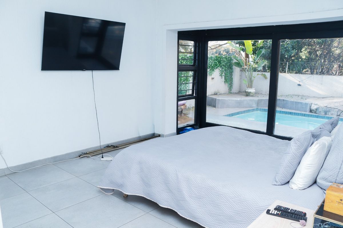Bedroom featuring tiled flooring and large sliding glass doors providing direct access to the pool area.