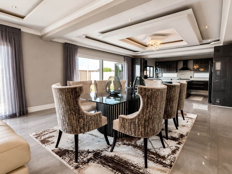 Spacious open-plan living and dining area featuring modern tiled floors, a sophisticated recessed ceiling, and a seamless transition to a contemporary kitchen.