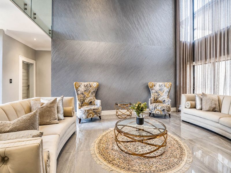 Spacious double-volume living room featuring a striking textured feature wall, polished porcelain flooring, and expansive full-height windows with elegant drapery.