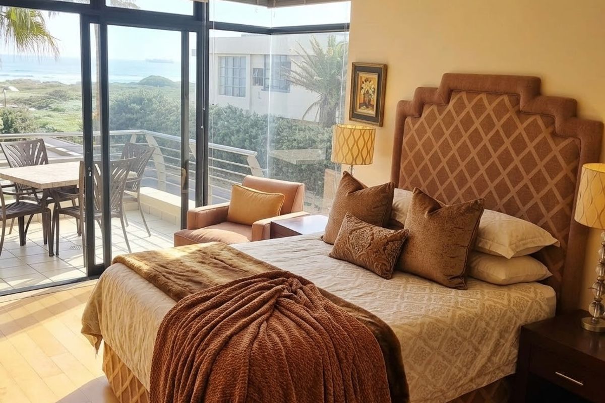 Spacious bedroom featuring hardwood flooring, recessed lighting, and large sliding glass doors opening onto a private balcony with ocean views.