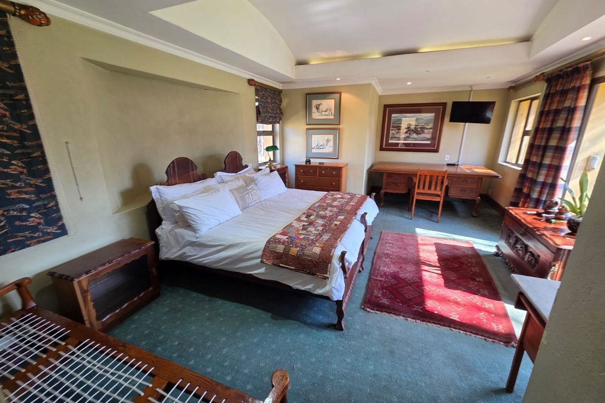 Spacious bedroom featuring a tray ceiling with recessed lighting and a built-in desk area, offering a comfortable and functional living space.