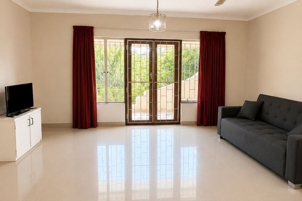 Spacious living room featuring polished tiled flooring, a ceiling fan, and glass sliding doors leading to an outdoor area.