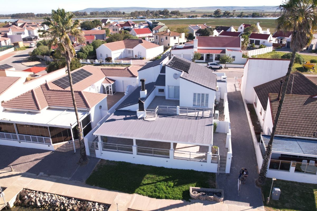 Aerial view of a residential property featuring a metal roof, solar panels, and a spacious balcony overlooking the surrounding neighborhood.