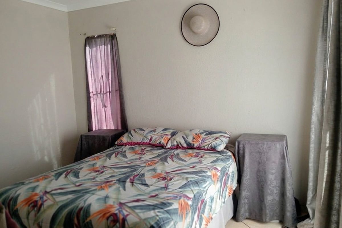 A standard bedroom featuring tiled flooring and neutral wall finishes, providing a functional space for rest.