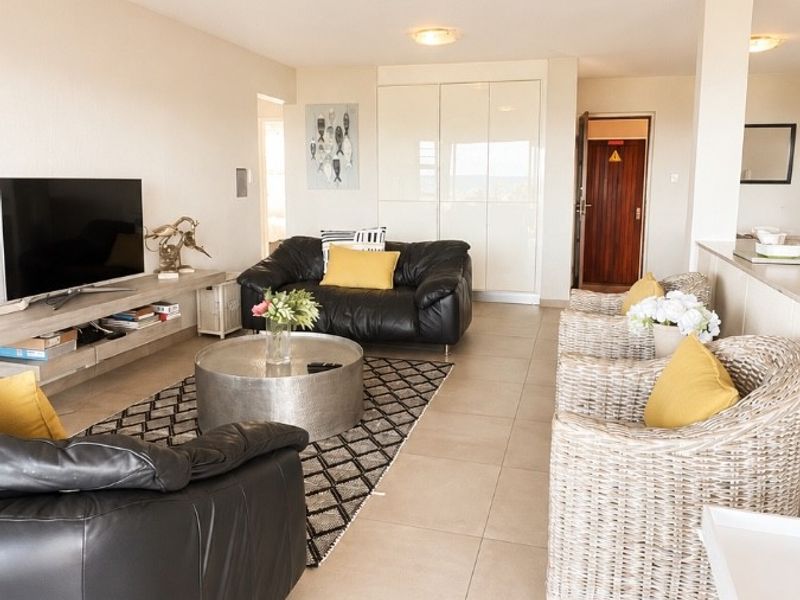 Spacious open-plan living area featuring neutral tiled flooring, built-in storage cupboards, and bright, functional lighting throughout the space.