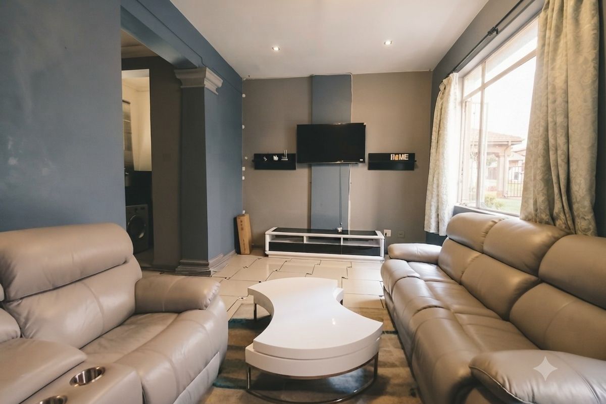 A comfortable living room featuring tiled flooring, recessed lighting, and a large window allowing for natural light.