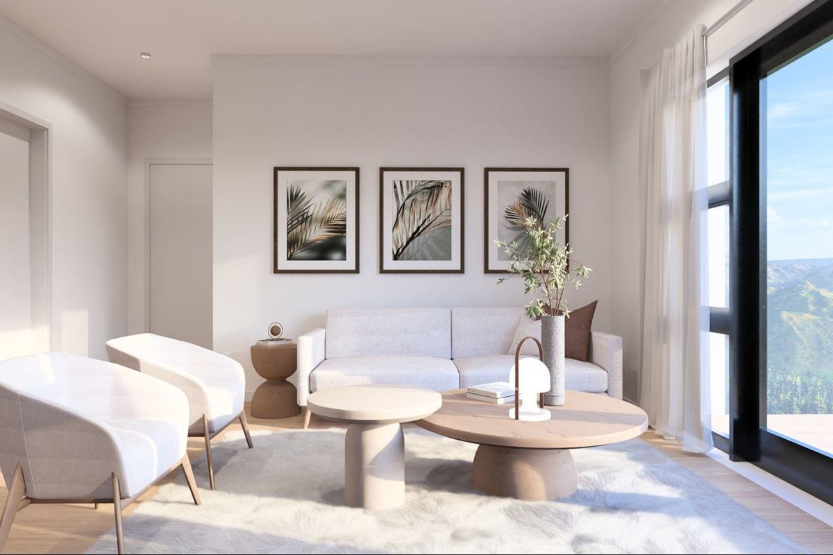 A bright and modern living room featuring timber flooring, recessed downlights, and a large sliding glass door providing natural light and scenic views.
