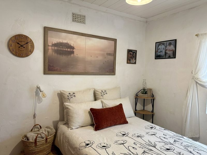 A cozy bedroom featuring a white timber ceiling and neutral wall finishes, providing a simple and functional sleeping space.